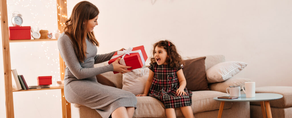 🌸 Give the Gift of Radiant Hair young woman giving present to daughter. mother and child posing with gift in holiday